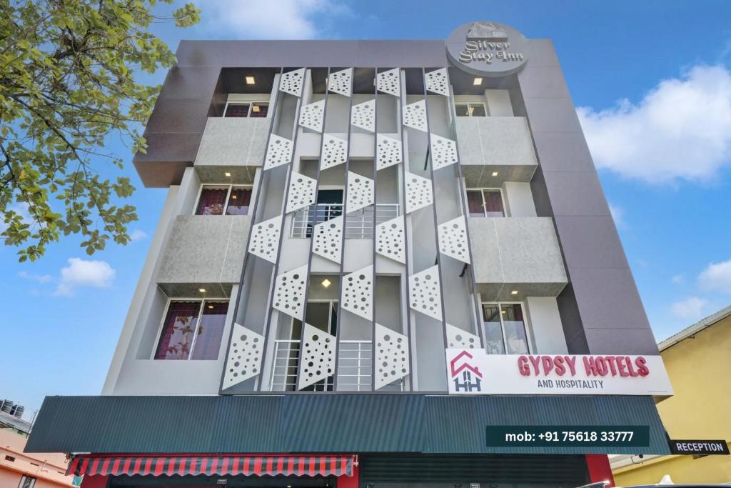 Un edificio alto con un cartel. en GYPSY HOTEL CUSAT, en Kochi
