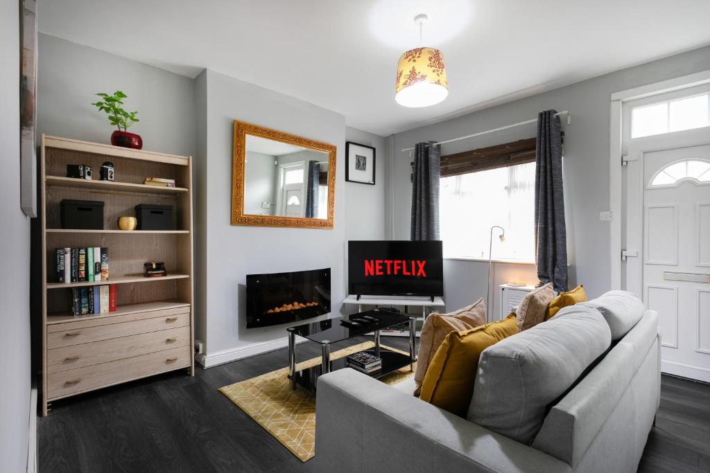 een woonkamer met een bank en een televisie bij Luxury 3BR House - Free Parking and Stunning Garden! in Nottingham