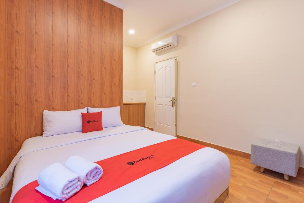 a bedroom with a large bed with towels on it at RedDoorz Plus @ Bagusrangin Street 2 in Bandung