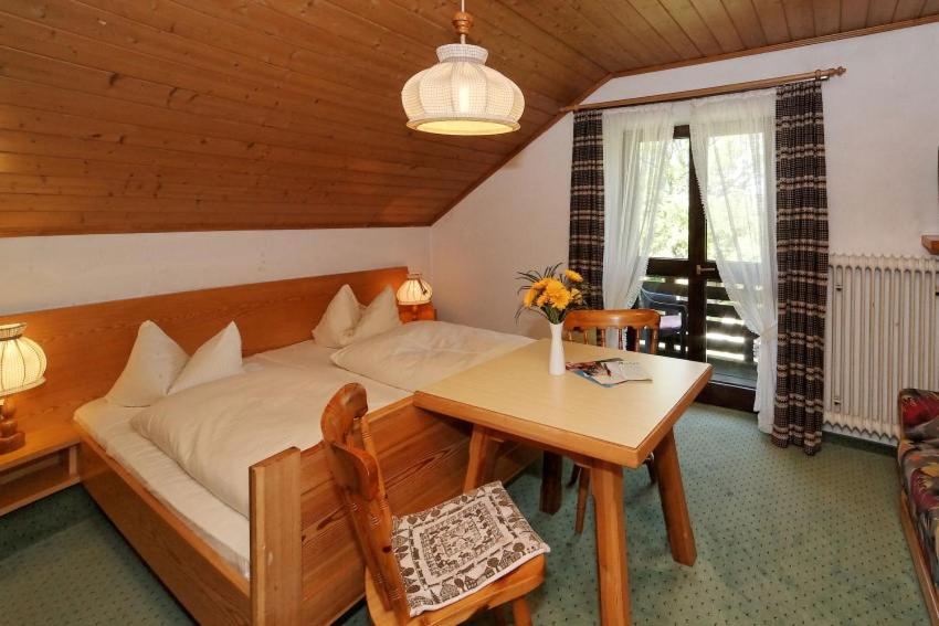 Schlafzimmer mit einem Bett und einem Tisch sowie einem Tisch und Stühlen in der Unterkunft Haus Jupp in Zandt