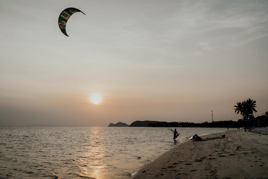 una persona sta volando un aquilone sulla spiaggia di Soukaina Beach Bungalow a Ko Phangan