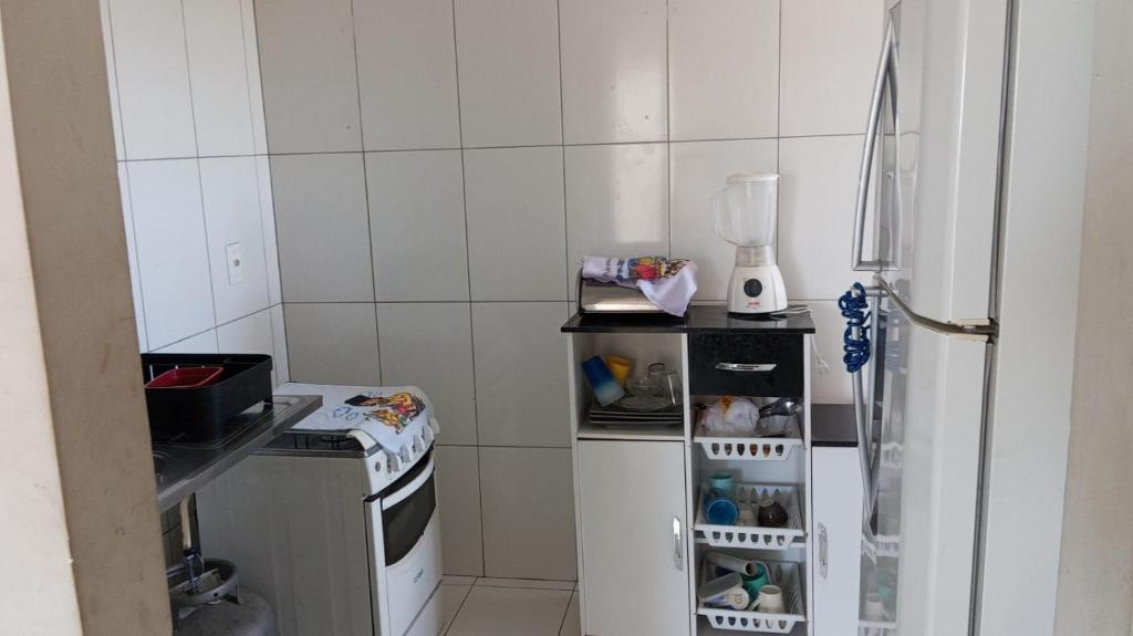 Il comprend une petite cuisine équipée d'un réfrigérateur et d'une cuisinière. dans l'établissement Condomínio morada real, à Petrolina