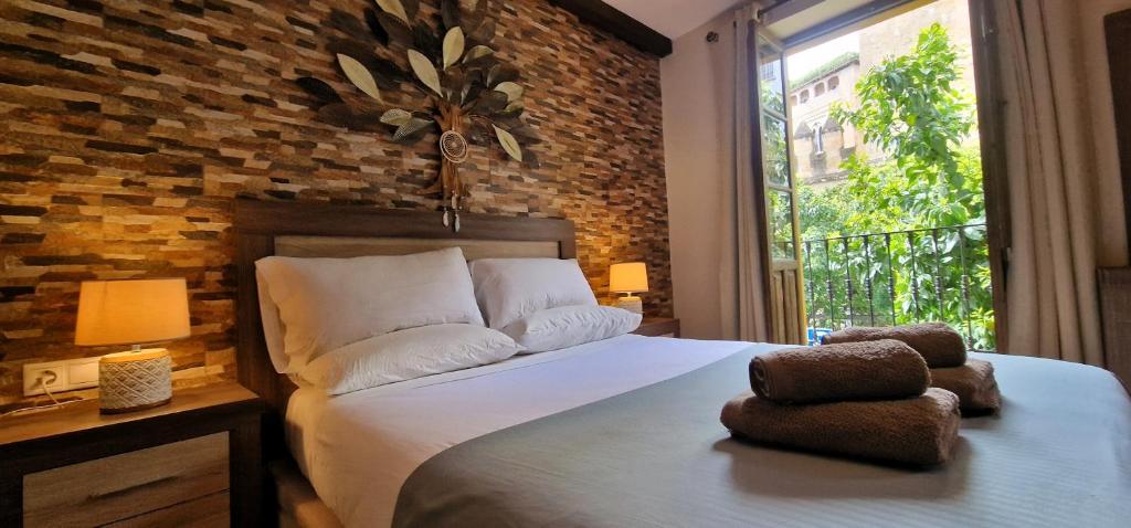 1 dormitorio con cama y pared de ladrillo en DS Casa San Fernando, en Córdoba