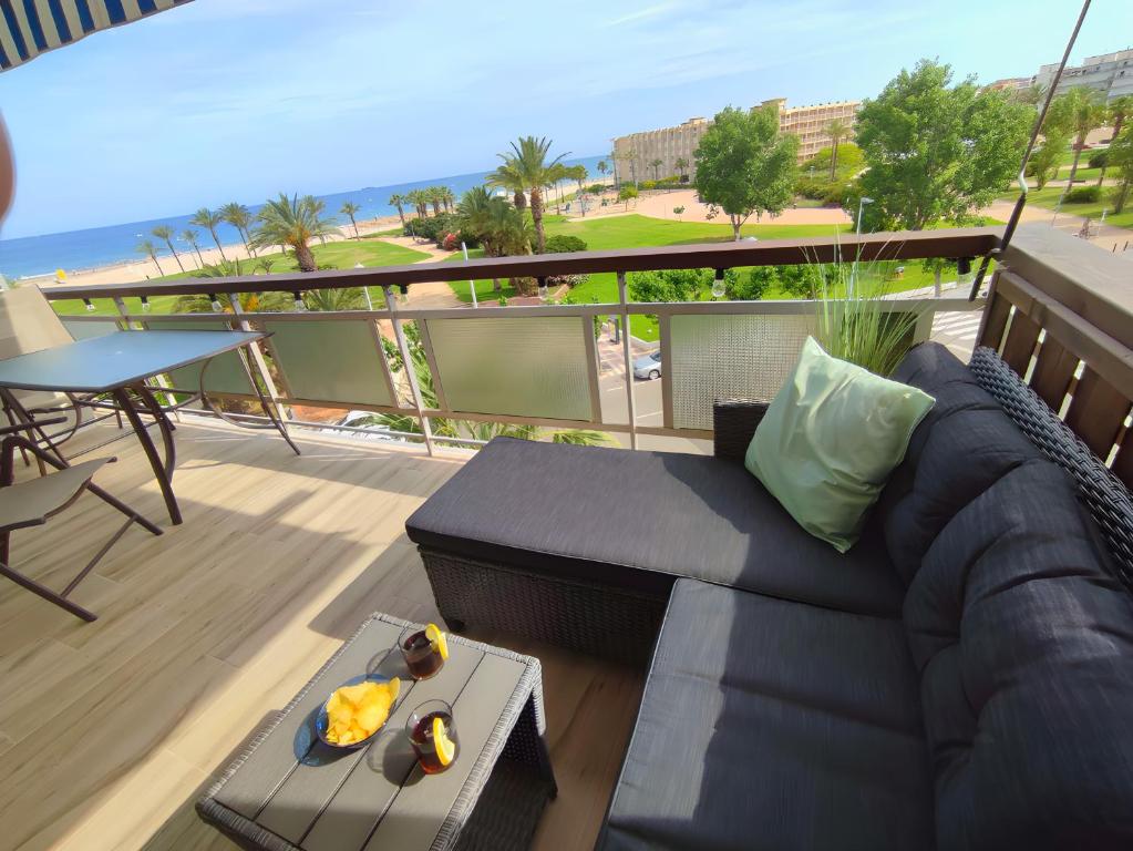 uma sala de estar com um sofá e uma mesa na varanda em Arrecife Beach em La Pineda