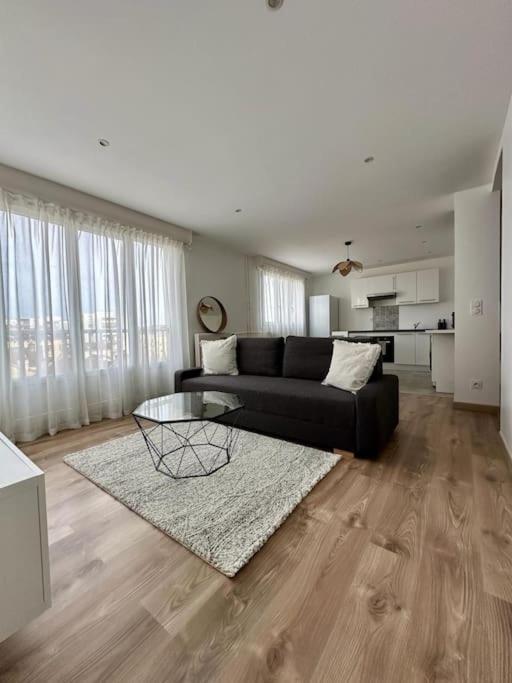 un salon avec un canapé noir et une table dans l'établissement Le 41, à Dijon