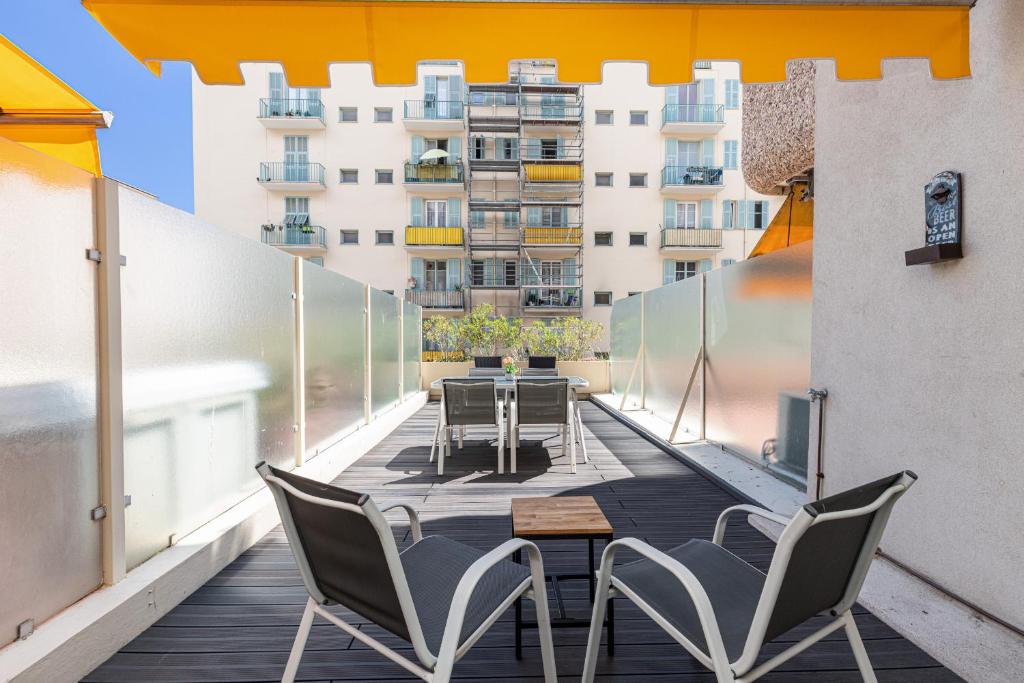 un balcon avec des chaises et une table sur un immeuble dans l'établissement 1 Bdr Large Terrace, à Nice