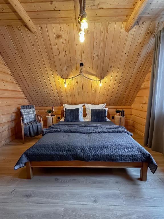 sypialnia z dużym łóżkiem w drewnianym suficie w obiekcie Domek & Apartament Góralski z Jacuzzi Kościelisko w mieście Kościelisko