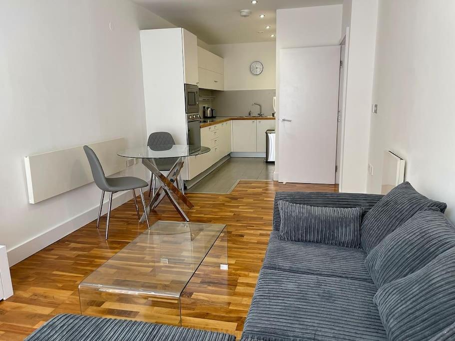 een woonkamer met een bank en een tafel bij Manchester's Prime - Luxurious 1-Bed Flat in Manchester