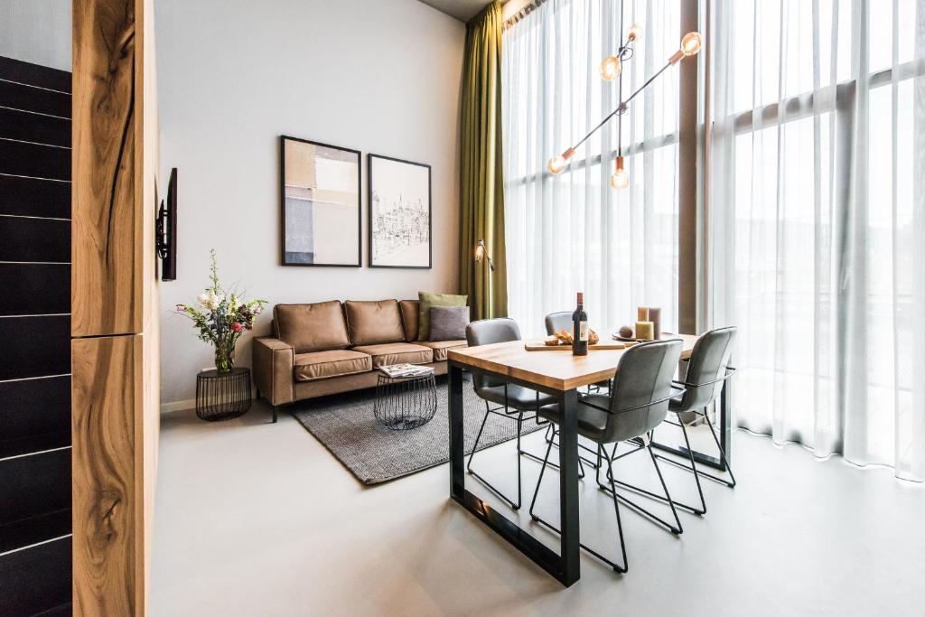 ein Wohnzimmer mit einem Tisch, Stühlen und einem Sofa in der Unterkunft YAYS Amsterdam East by Numa in Amsterdam