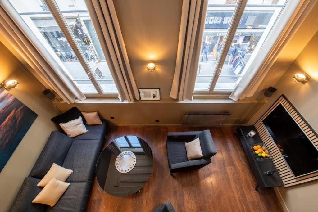 - une vue de tête sur un salon doté de meubles et de fenêtres dans l'établissement Paris 1er - Magnifique duplex, à Paris