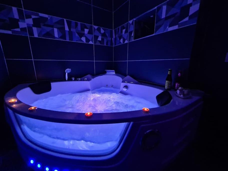 La salle de bains est pourvue d'une baignoire bleue avec des lumières. dans l'établissement F**K ROOM, à Perpignan