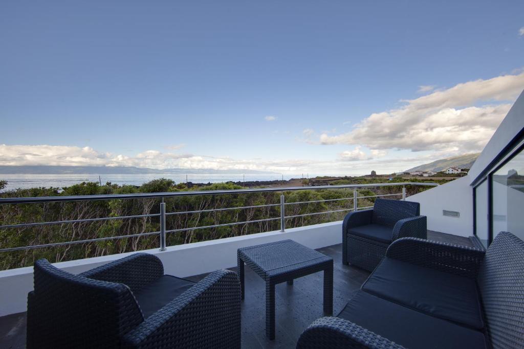 Un balcón con sillas y vistas al océano. en Casas da Junqueira, en Prainha de Baixo