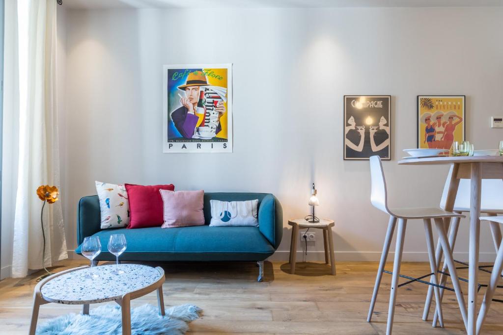 un salon avec un canapé bleu et une table dans l'établissement Refined & Cozy 1 Bedroom Downtown, à Nice