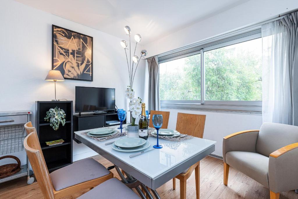 un salon avec une table et des chaises et une fenêtre dans l'établissement Central 1 Bdr, à Nice
