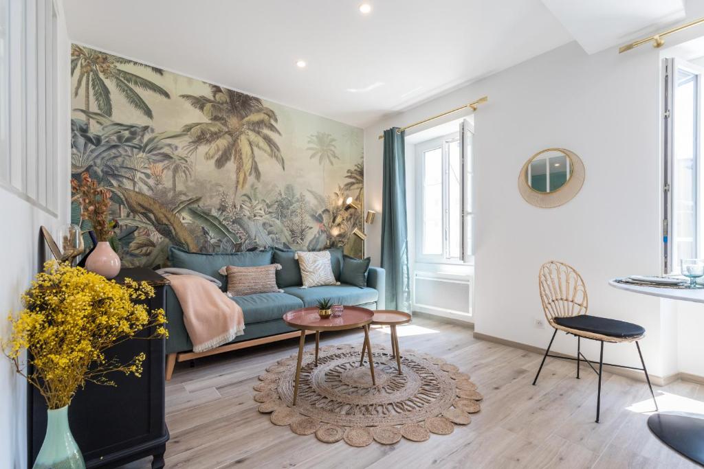 a living room with a blue couch and a mural at Lovely Apartment City Center Heart - AC in Nice