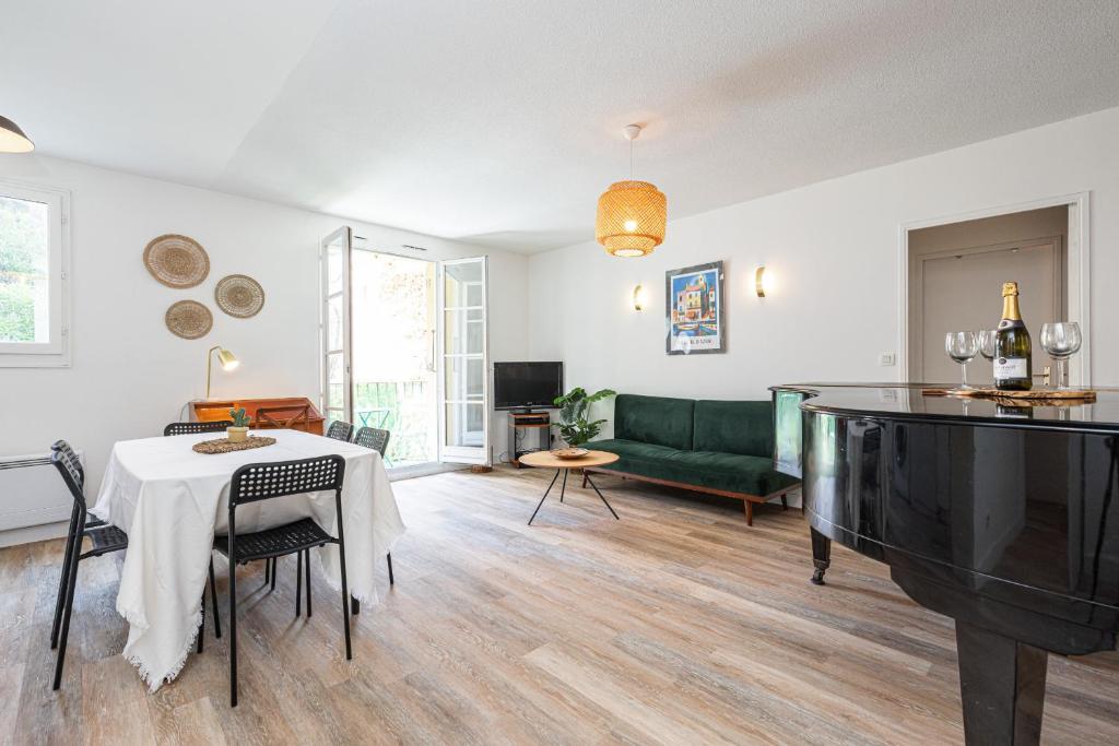 - un salon avec une table et un canapé vert dans l'établissement 2 Bdrs & Parking in the Old Town !, à Nice