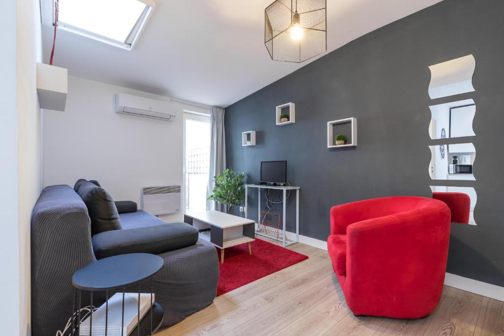 ein Wohnzimmer mit einem Sofa und einem roten Stuhl in der Unterkunft Magenta Square Central 1 Bdr with AC in Nizza