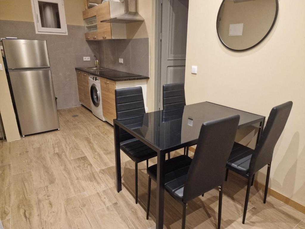 eine Küche mit einem Tisch und Stühlen sowie einem Kühlschrank in der Unterkunft Apartamento Centro do Mindelo 6 min da praia in Mindelo