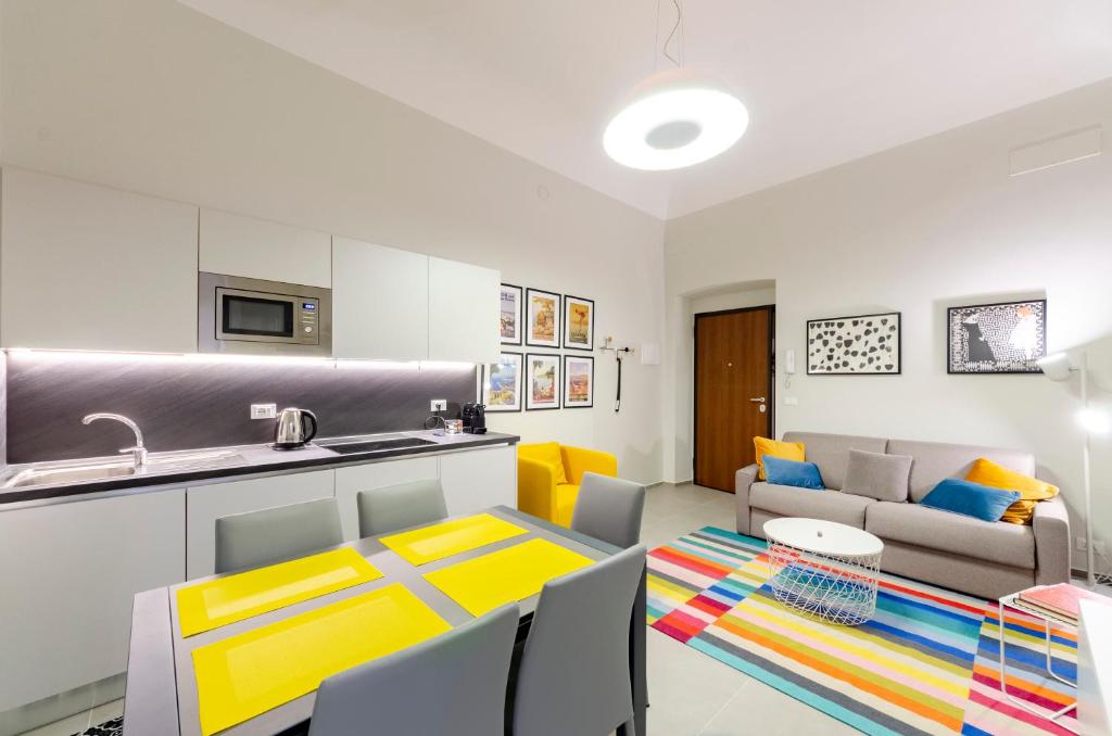 eine Küche und ein Wohnzimmer mit einem Tisch und einem Sofa in der Unterkunft JOIVY The Place To Be in the Centre of Genoa in Genua