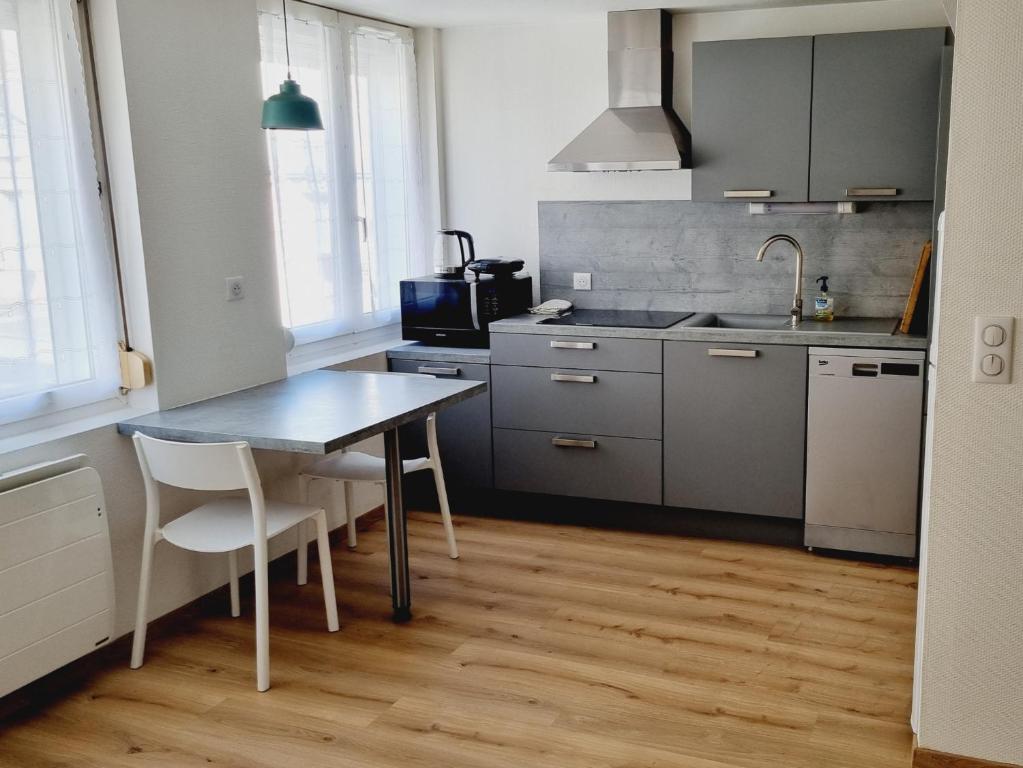 - une cuisine avec une table et des chaises dans la chambre dans l'établissement Moulins Studio cœur de ville de Saint Dizier, à Saint-Dizier