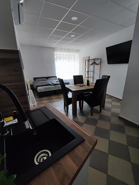 a kitchen and living room with a table and chairs at Bástya Apartman in Tata