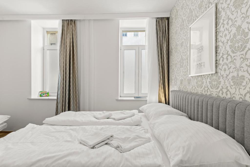 維也納的住宿－StayEasy Apartments Vienna A#2，一间卧室配有两张带白色床单的床