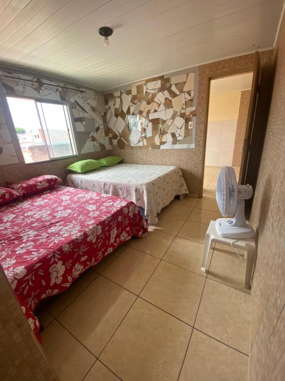 een slaapkamer met 2 bedden en een stoel. bij Flats com cozinha in Feira de Santana