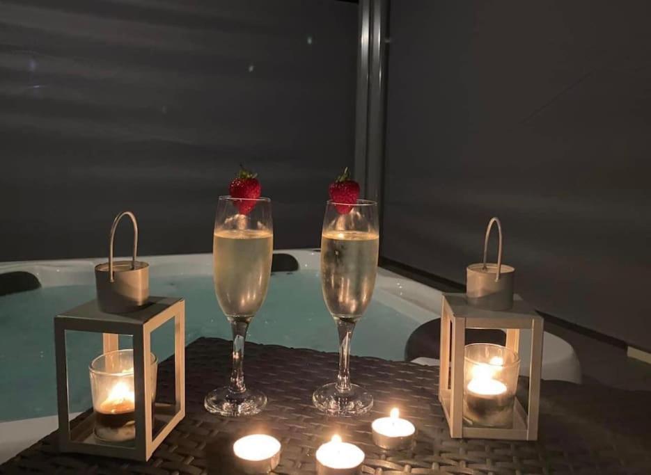 einen Tisch mit zwei Gläsern Champagner und Kerzen in der Unterkunft Luxury Hot Tub Lodge 5 Star Country Park Huge Veranda Colour Change Hot Tub Private Fishing FREE Parking in Little Habton