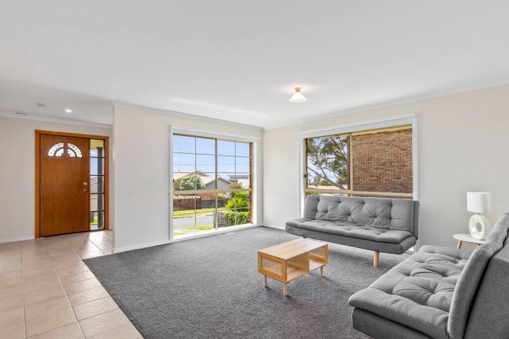 a living room with two couches and a table at Beautiful 3 bedroom house with Corio Bay view at heart of Clifton Springs in Clifton Springs