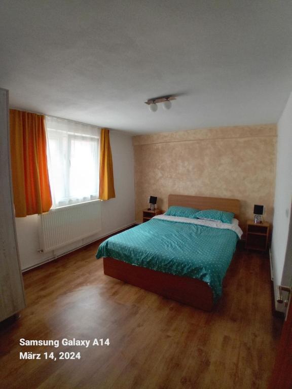 a bedroom with a bed with a green comforter at Perfekte Rast in Sibiu