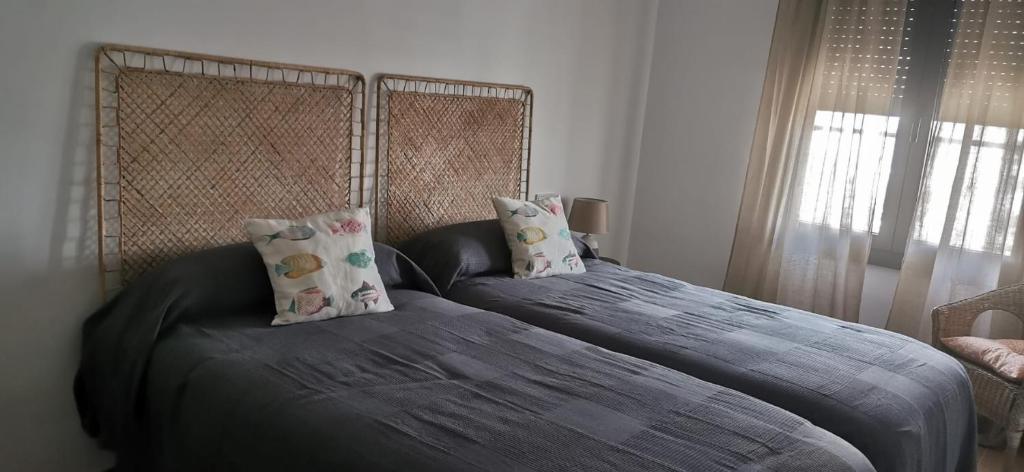 a bedroom with two twin beds and a chair at Hostal Sa Malica in Blanes