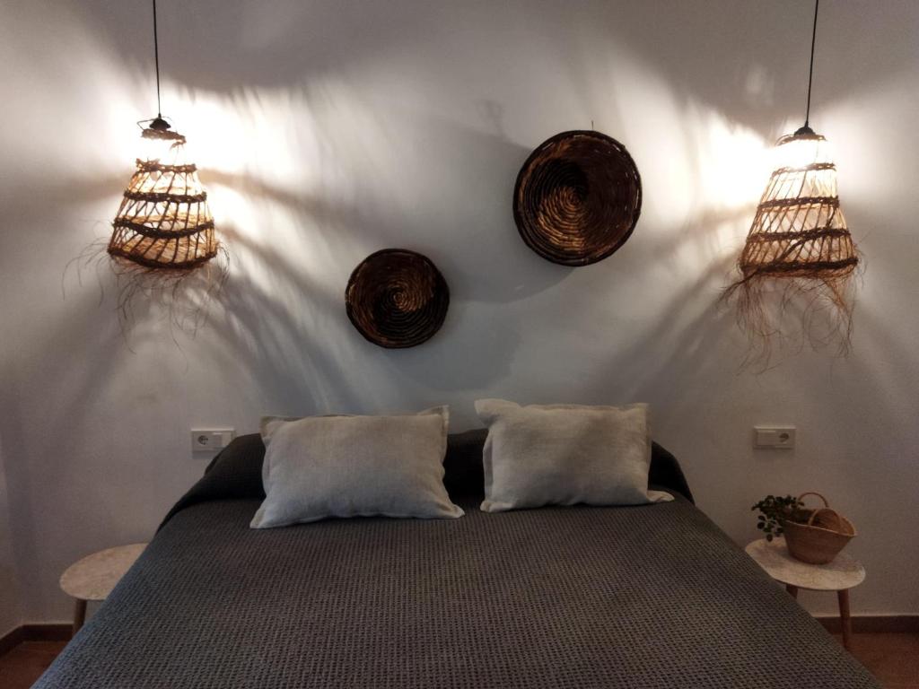 a bedroom with a bed and three hanging baskets at Hostal Sa Malica in Blanes