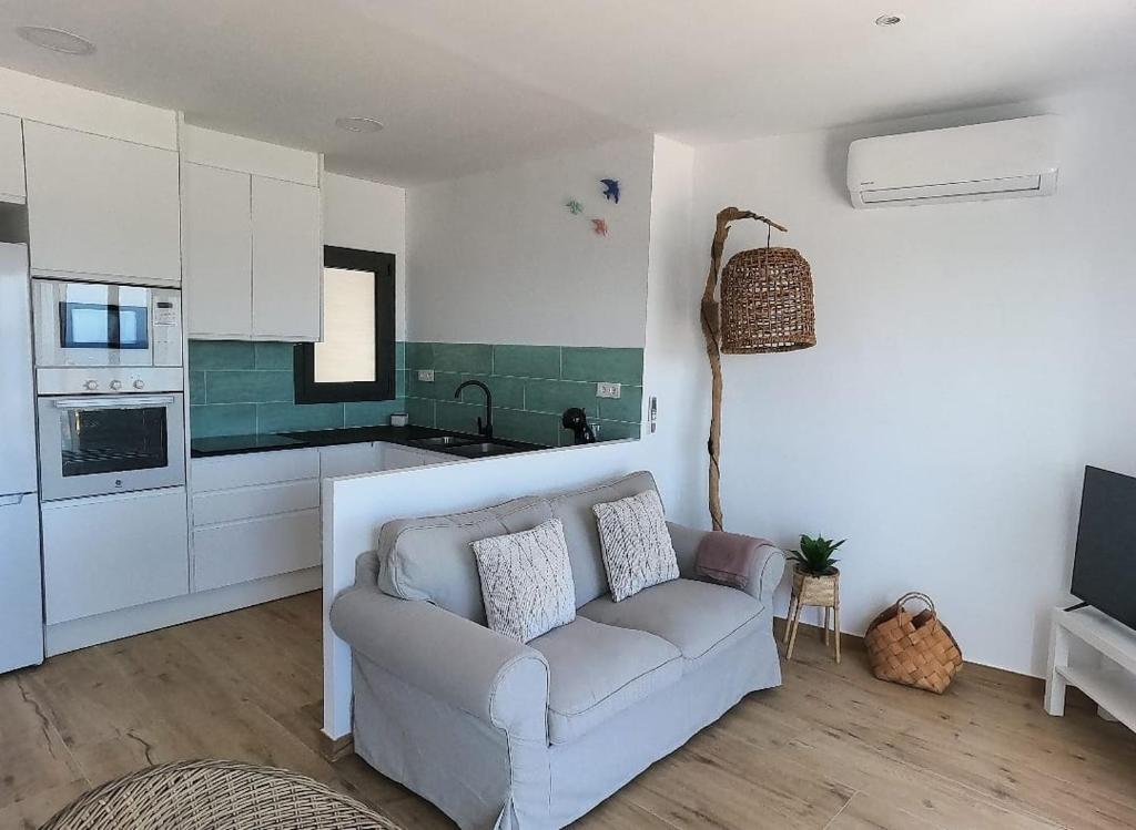 a living room with a couch and a kitchen at Hostal Sa Malica in Blanes