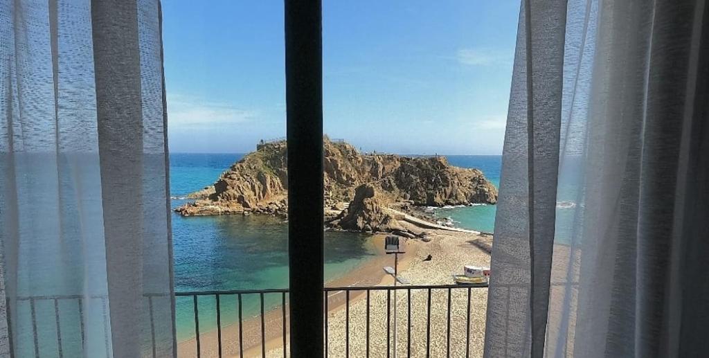 a view of a beach from a hotel window at Hostal Sa Malica in Blanes