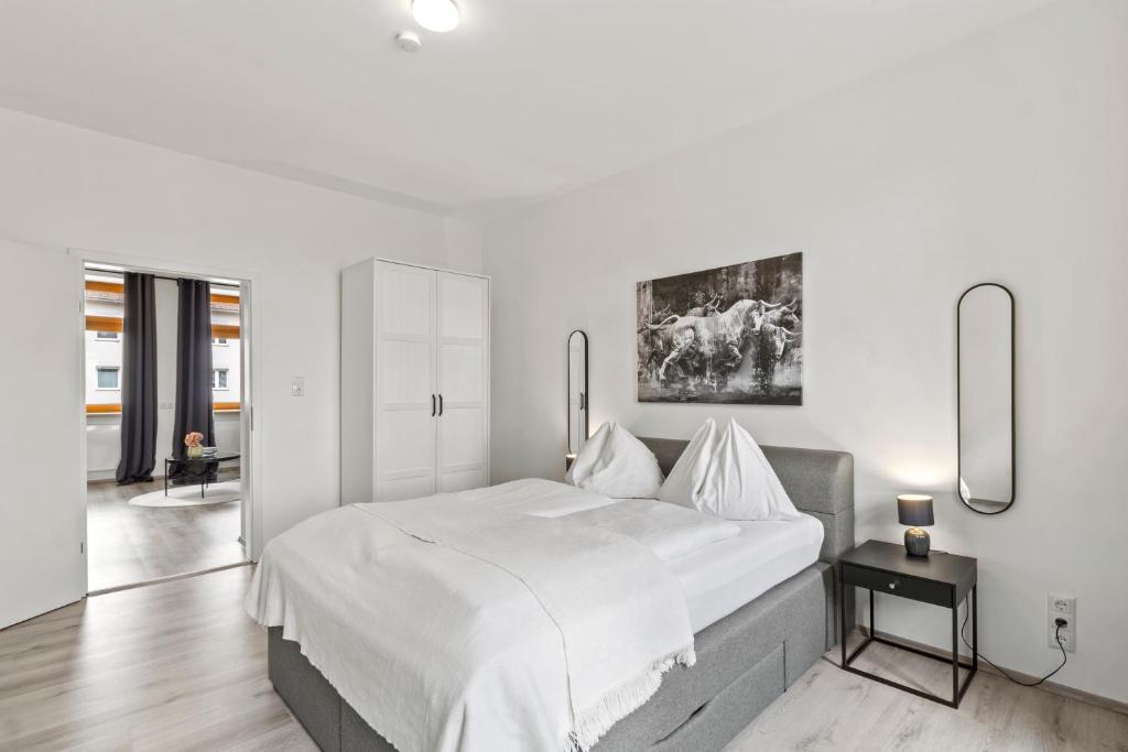 a white bedroom with a large bed and a table at StayEasy Apartments St. M. 2 