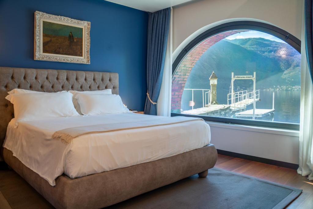 um quarto com uma cama grande e uma janela em arco em Villa Lario Resort Mandello em Mandello del Lario