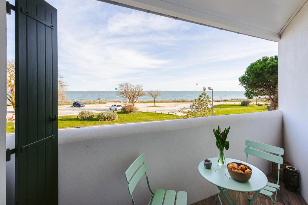 balcón con mesa, sillas y vistas al océano en Le Phare, Studio vue mer, en Rivedoux-Plage