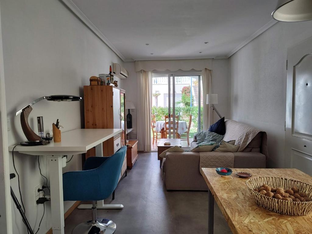 ein Wohnzimmer mit einem Tisch und einem Sofa in der Unterkunft Vera Playa Apartamento muy cuco con jardín y 2 habitaciones in Vera