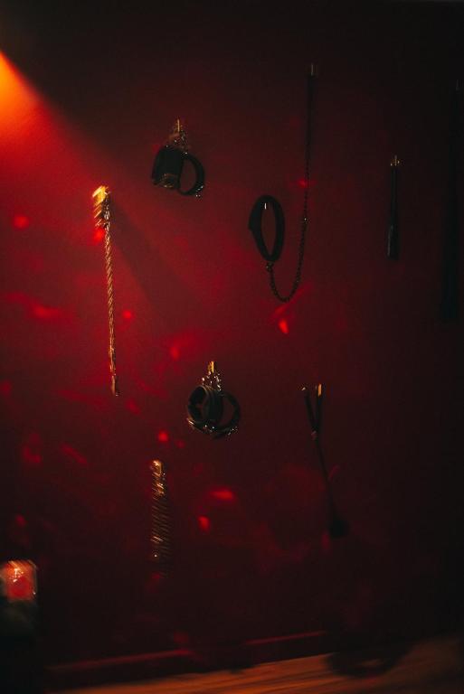 une chambre sombre avec des lumières rouges sur un mur dans l&#39;établissement 50 Nuances d&#39;Amour - Jacuzzi &#47; Massage &#47; Cinéma, à Moirans