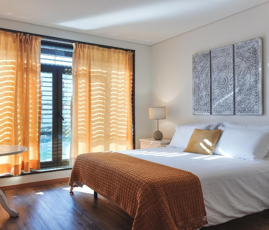 - une chambre avec un lit et une grande fenêtre dans l'établissement Casa Ponte Pedrinha, à Tarouca