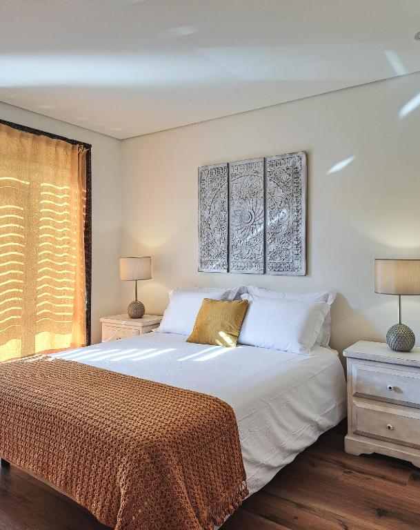 a bedroom with a large white bed and a window at Casa Ponte Pedrinha in Tarouca