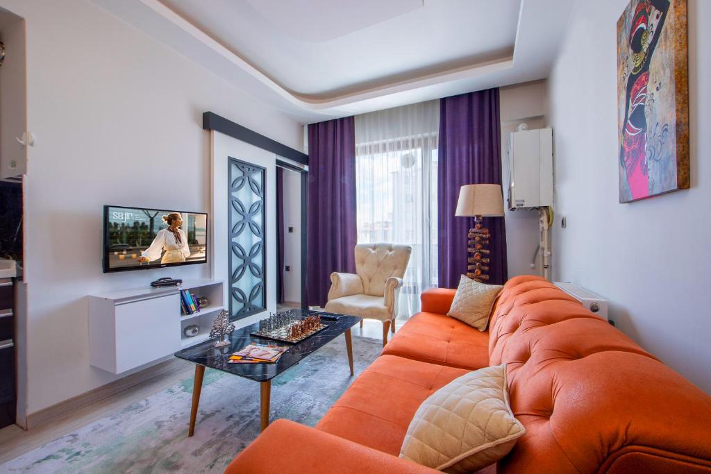 a living room with an orange couch and a table at SEYİREVLERİ SUİT ŞUBESİ in Melikgazi