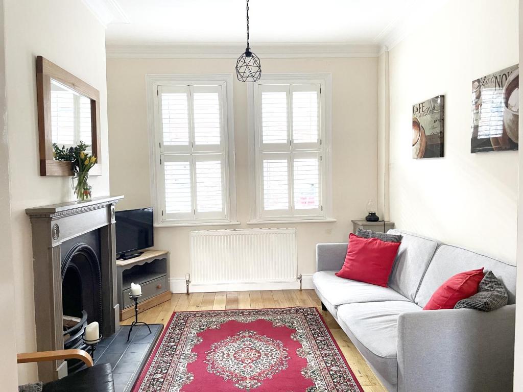 a living room with a couch and a fireplace at Riverside Lodge - Quaint Victorian Home By The River in York