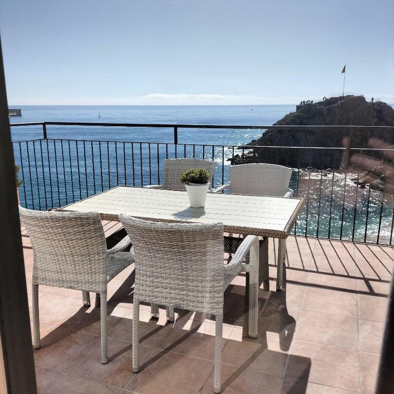 a table and chairs on a balcony with the ocean at Hostal Sa Malica in Blanes