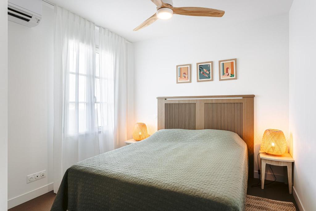 1 dormitorio con 1 cama y ventilador de techo en Les iles, T2 vue mer, en Rivedoux-Plage