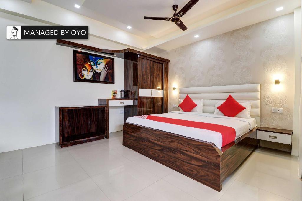 una camera da letto con un grande letto con cuscini rossi di Super OYO Natraj Inn Near SGPGI - Managed by Company a Lucknow