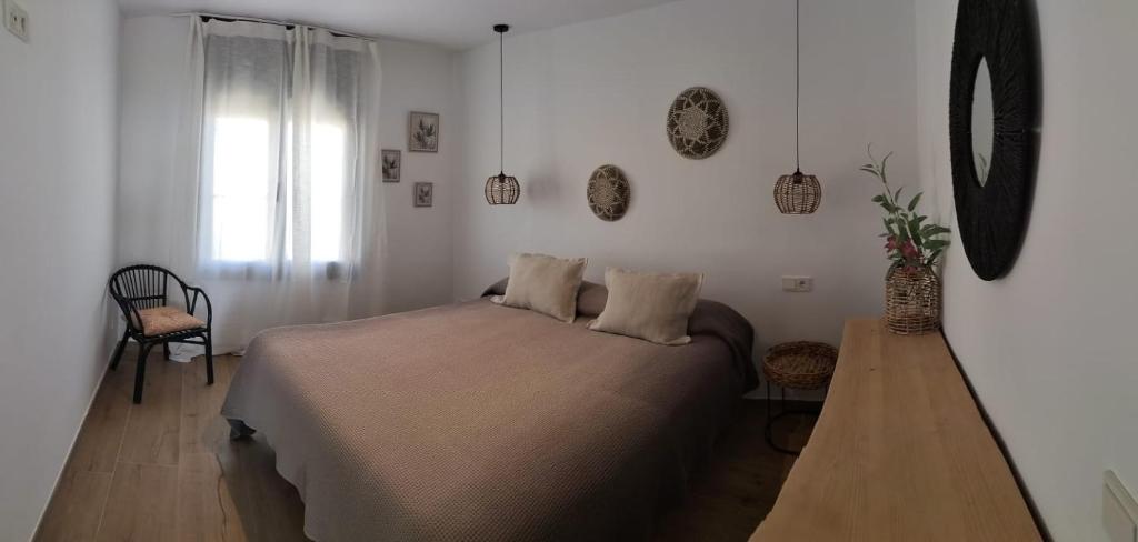 a bedroom with a bed and a chair and a window at Hostal Sa Malica in Blanes