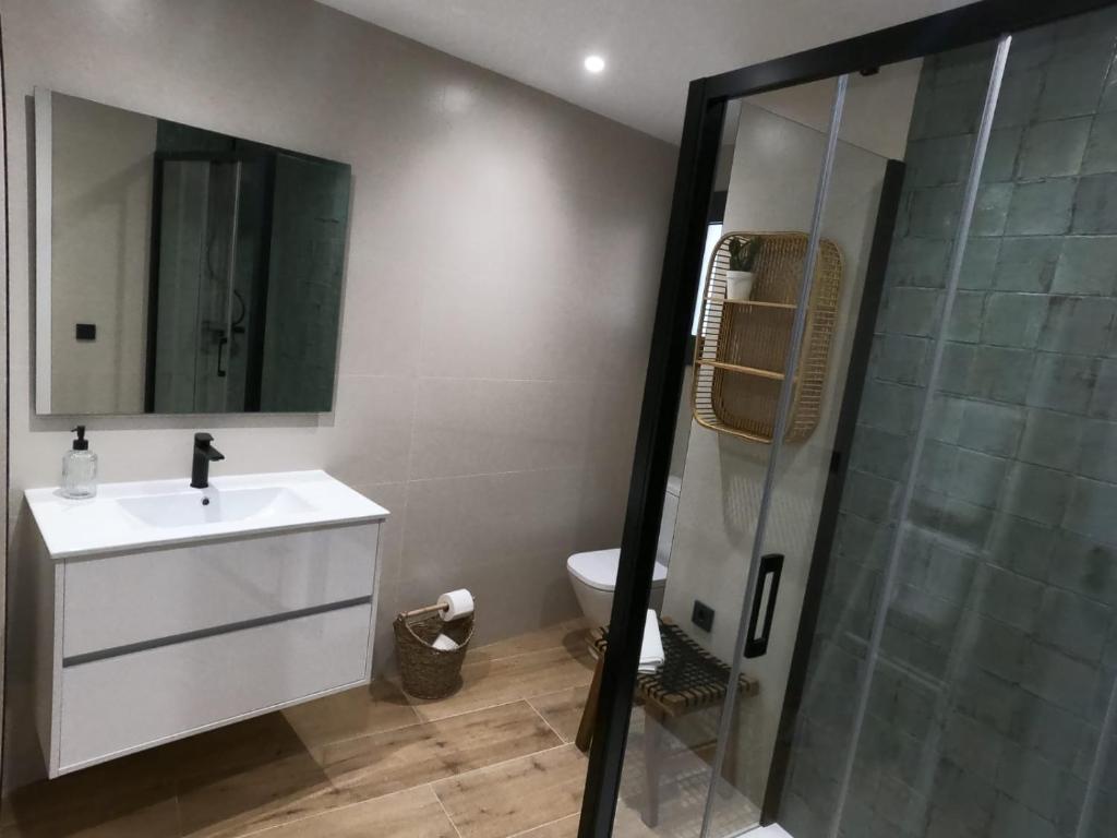 a bathroom with a sink and a glass shower at Hostal Sa Malica in Blanes