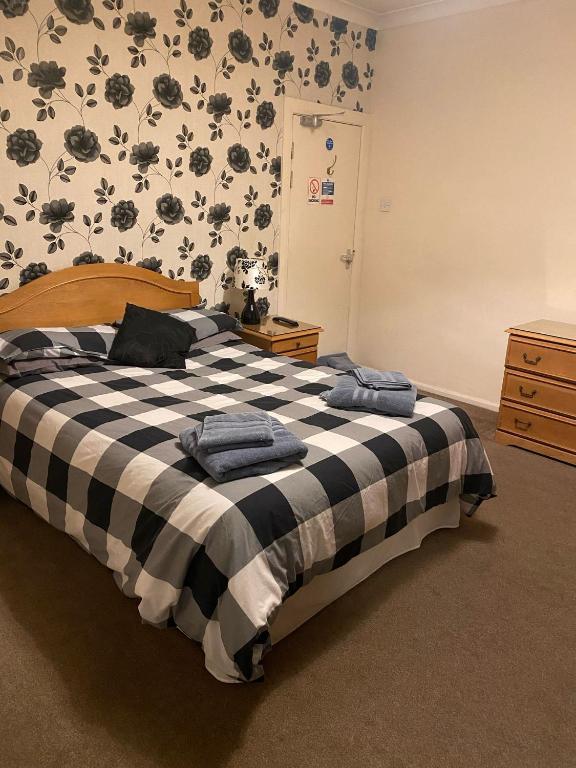 a bedroom with a bed with a black and white blanket at The Bowmans in Howden