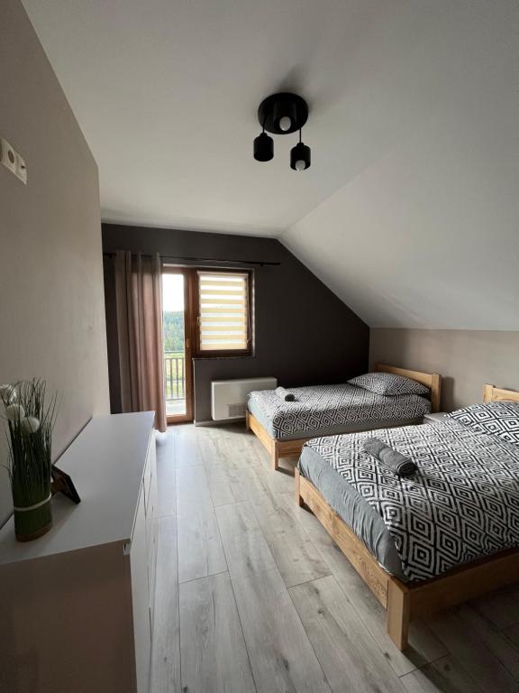 a bedroom with two beds and a desk in it at Domki na Maciejce Domek 15 osobowy i 7 osobowy in Jaworzynka